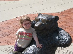 Glasses are uncommon on young children, and even less common in bear statues.