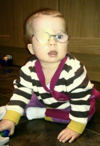 Evie in her patch and glasses at 8 months