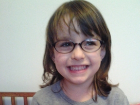 4 year old girl wearing glasses for astigmatism and thin optic nerve