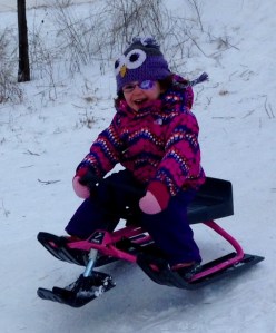 girl wearing an eye patch on a sled